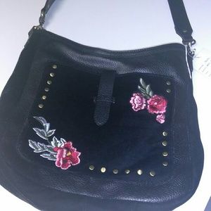 A black cross over handbag with flowers